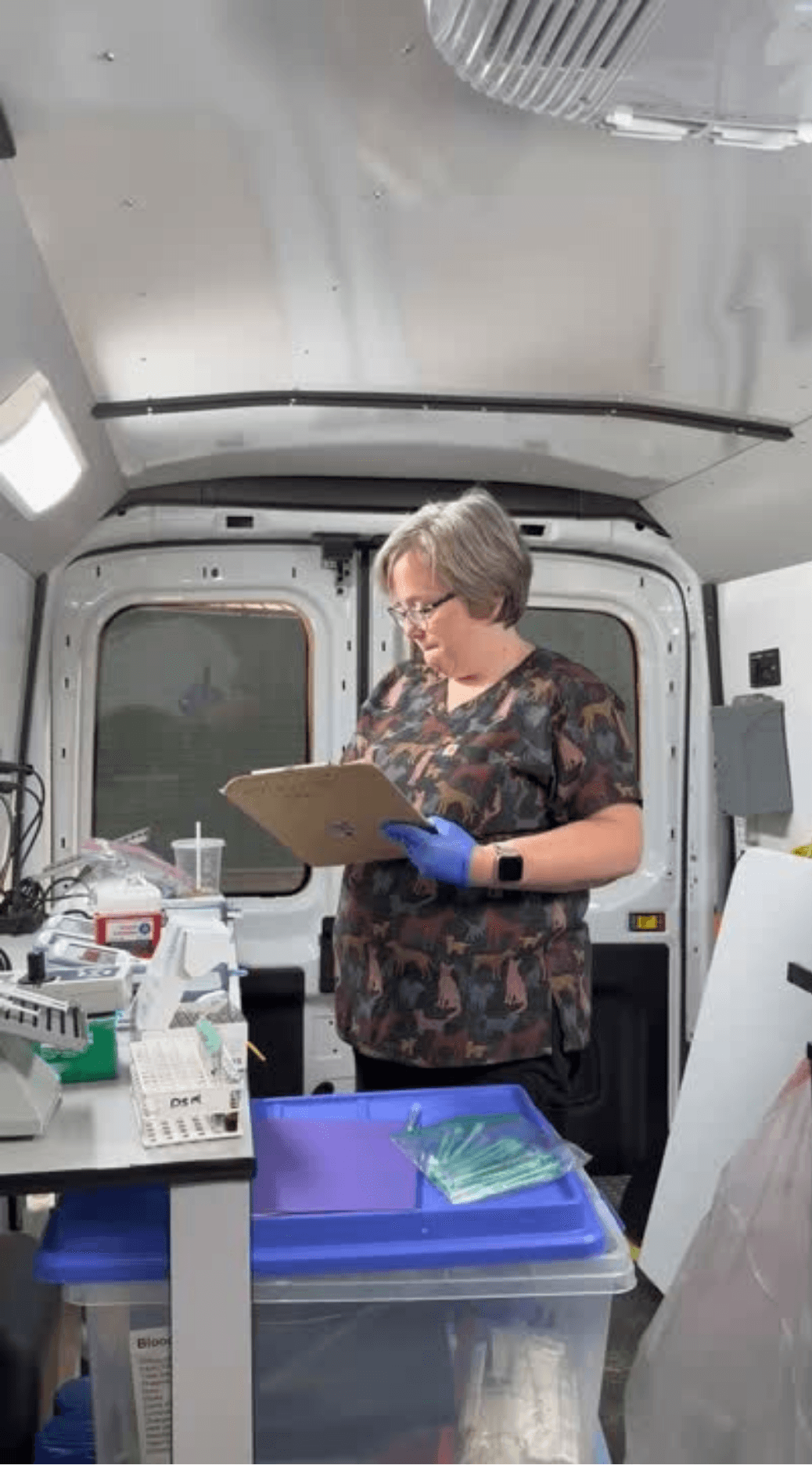 Dr. Casey Bradley, PhD, conducting on-farm poultry nutrition research and recording data in a production facility